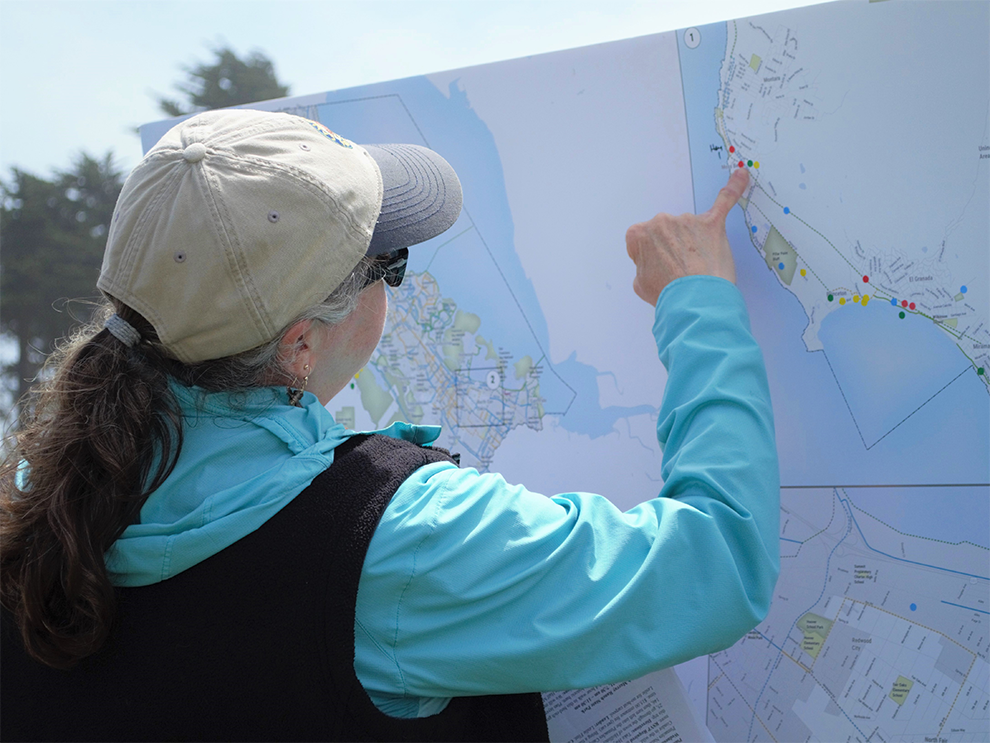 Woman points to map of Unincorporated San Mateo County to provide feedback on walking and biking.